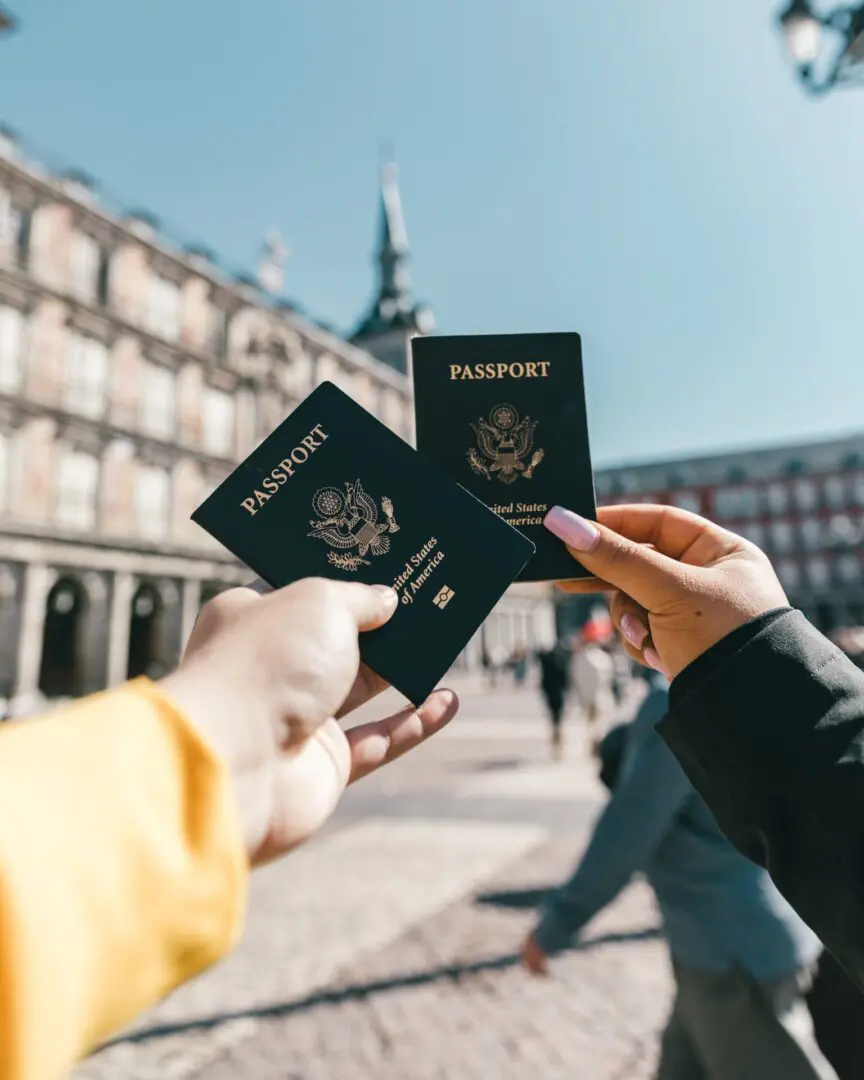 Two hands holding up their passports together